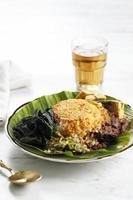 Rendang Padang. Spicy beef stew from Padang, Indonesia. Nasi Padang consisting of white rice, rendang, and vegetables in a white plate. photo