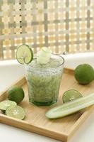 Es Timun Serut made from Shredded Cucumber, Lime Juice, and Basil Seeds, Served on Clear Glass on Wooden Table photo