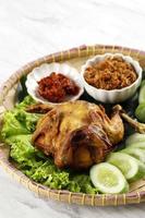 ayam ingkung goreng o bakakak hayam, pollo entero frito foto