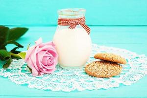 Lunch and pink rose on blue wooden background and lace napkin. Top view and copy space. Selective focus photo