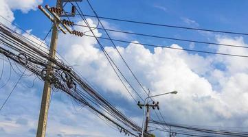 caos absoluto del cable en el poste de energía tailandés cielo azul de tailandia. foto