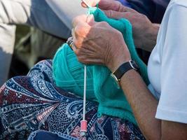 ISLE OF THORNS, SUSSEX, UK, 2016. Woman knitting at a Lawn Bowls Match photo