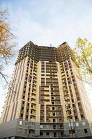 Construction of a multi-storey apartment building in the city. A crane near a skyscraper. Building, moving to a new flat, mortgage, rent and purchase real estate. Copy space photo