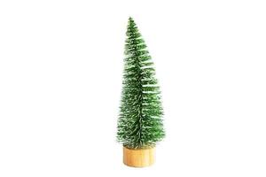 Green artificial Christmas tree in the shape of a triangular brush on a wooden round stand, on a white background, isolate. Christmas, new year, symbol of the holiday. photo