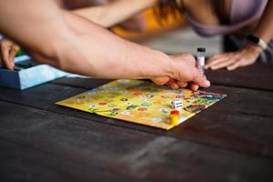 Kaluga, Russia - June 20, 2020. Board game Ekivoki, chips, cube, timer on a table and hands in background. Teamwork, intellectual relaxation, corporate event, playing at home with children. Copy space photo