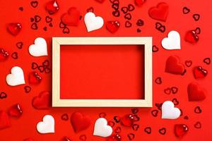 Text or photo frame in the center, surrounded by hearts. Decor of couples in love with hearts on a red background. Valentine's Day, message, greeting, declaration of love. Copy space