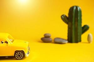 Summer trip by car-a yellow car on a background with a cactus-a tour to the desert, to the sea. Independent travel, domestic tourism. Taxi for an excursion. Copy space photo
