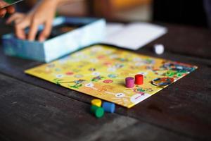 Kaluga, Russia - June 20, 2020. Board game Ekivoki, chips, cube, timer on a table and hands in background. Teamwork, intellectual relaxation, corporate event, playing at home with children. Copy space photo