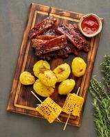 Spicy barbecue pork ribs, corn ears and crushed smashed potatoes. Slow cooking recipe