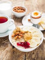 oatmeal with nuts and jam, soft boiled eggs, selective focus, side view, vertical frame photo