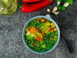 Healthy spring vegetable dietary vegetarian soup, gray dark concrete background, top view, close up. photo