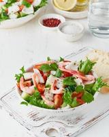 Seafood salad with squid, shrimp, cucumbers, tomatoes and lettuce. LCHF, FODMAP, paleo diet photo