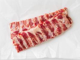 raw pork ribs on white parchment paper, top view photo