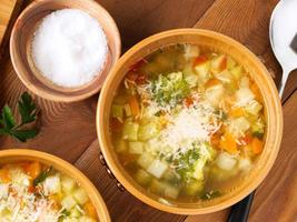 Two bowl of minestrone soup on rustic wooden background, top view, close up. photo