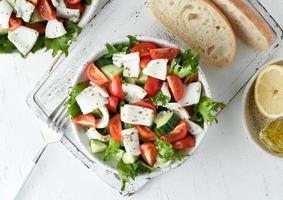 Salad with squid, cucumbers, tomatoes and lettuce. LCHF, FODMAP, paleo diet. Top view photo