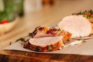 Baked in oven with aromatic herbs juicy pork tenderloin fillet cut into thin slices photo