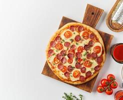 Top view hot homemade Italian pepperoni pizza with salami, mozzarella on white table