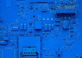 Computer motherboard. Classic blue background with pc backdrop, close up. Single color microchip photo