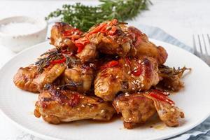 Barbecue chicken wings. Oven baked chiken on plate. Hot korean food. Side view, close up photo