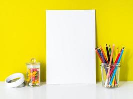 Mockup with clean white canvas, colored pencils on bright yellow background. Concept for creativity, drawing. photo