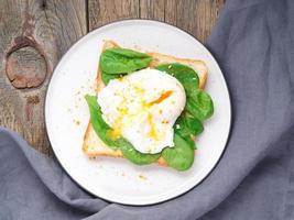 desayuno saludable con tostadas y huevo escalfado con ensalada verde, espinacas. vista superior. foto