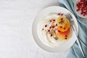 Sweet and healthy colorful dessert, Mixed fruit salad with coconut yoghurt. Copy space, top view photo