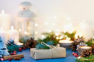 fondo de navidad con caja de regalo y decoraciones, velas y guirnaldas de luces. foto
