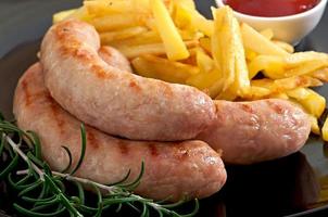 Chicken sausages grilled with a side dish of  french fries photo