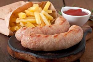 Chicken sausages grilled with a side dish of  french fries photo