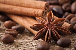 anís, canela y granos de café sobre fondo de madera antiguo foto