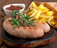 Chicken sausages grilled with a side dish of  french fries photo