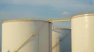 large Industrial tanks for petrol and oil with blue sky.Fuel tanks at the tank farm. metal stairs on the side of an industrial oil container. Staircase on big fuel tank