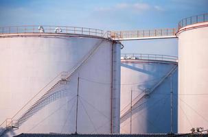 large Industrial tanks for petrol and oil with blue sky.Fuel tanks at the tank farm. metal stairs on the side of an industrial oil container. Staircase on big fuel tank photo