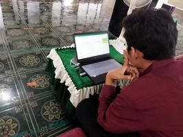 kasongan, indonesia, 2022-hombre trabajando frente a una computadora portátil foto