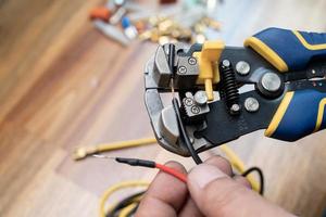 Wire strippers or cable strippers tool . Electrician holding cable strippers tool to remove insulation from electrical wires.Work Safely and Tools concept photo