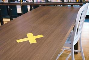 Yellow crosses labelled on the table . safe distancing rules in restaurants in Bangkok photo