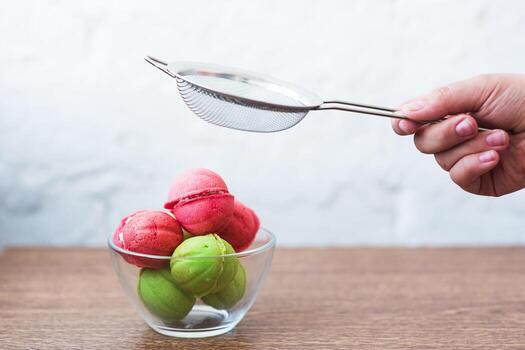 Multicolored cookies in the form of Nuts with filled cream in a glass transparent vase on table on a light background photo