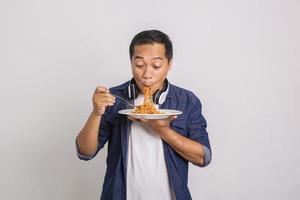 Asian man eating instant noodle and feel surprise with how delicious it is photo