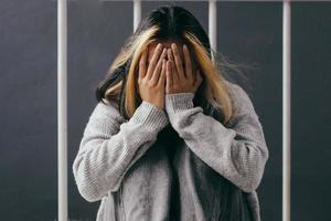 Depressed and sad young woman sitting alone at home photo