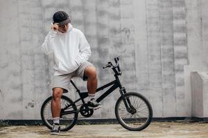 maqueta con capucha de un hombre en bicicleta. concepto de fotografía al aire libre para maqueta de sudadera con capucha foto