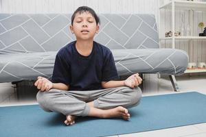 Children meditating at home on yoga mat photo