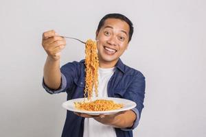 hombre asiático comiendo fideos instantáneos y se sorprende con lo delicioso que es