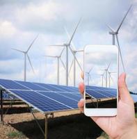 paneles solares y turbinas de viento con las nubes y el cielo foto