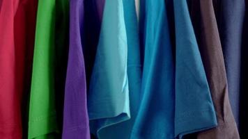 Close up of Colorful t-shirts on hangers video