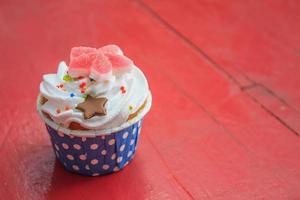 sabrosos cupcakes con crema de mantequilla, sobre fondo de madera de color foto