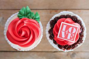 pastelitos de rosas rojas en la mesa de madera foto