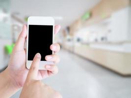 female using smartphone with blur hospital background photo