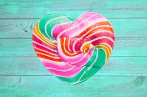 colorful heart lollipop on vintage color wood background photo