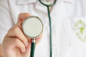 female doctor in white uniform holding stethoscope photo