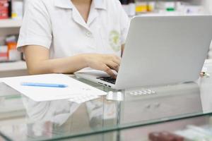 farmacéutico con computadora portátil y medicamentos en la farmacia foto